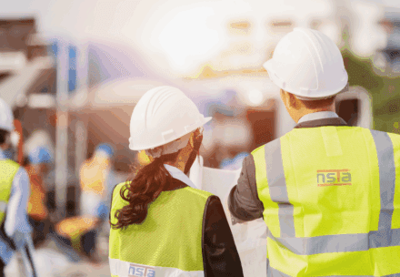 Construction worker in high-visibility vest giving thumbs up at worksite, promoting White Card NSW course
